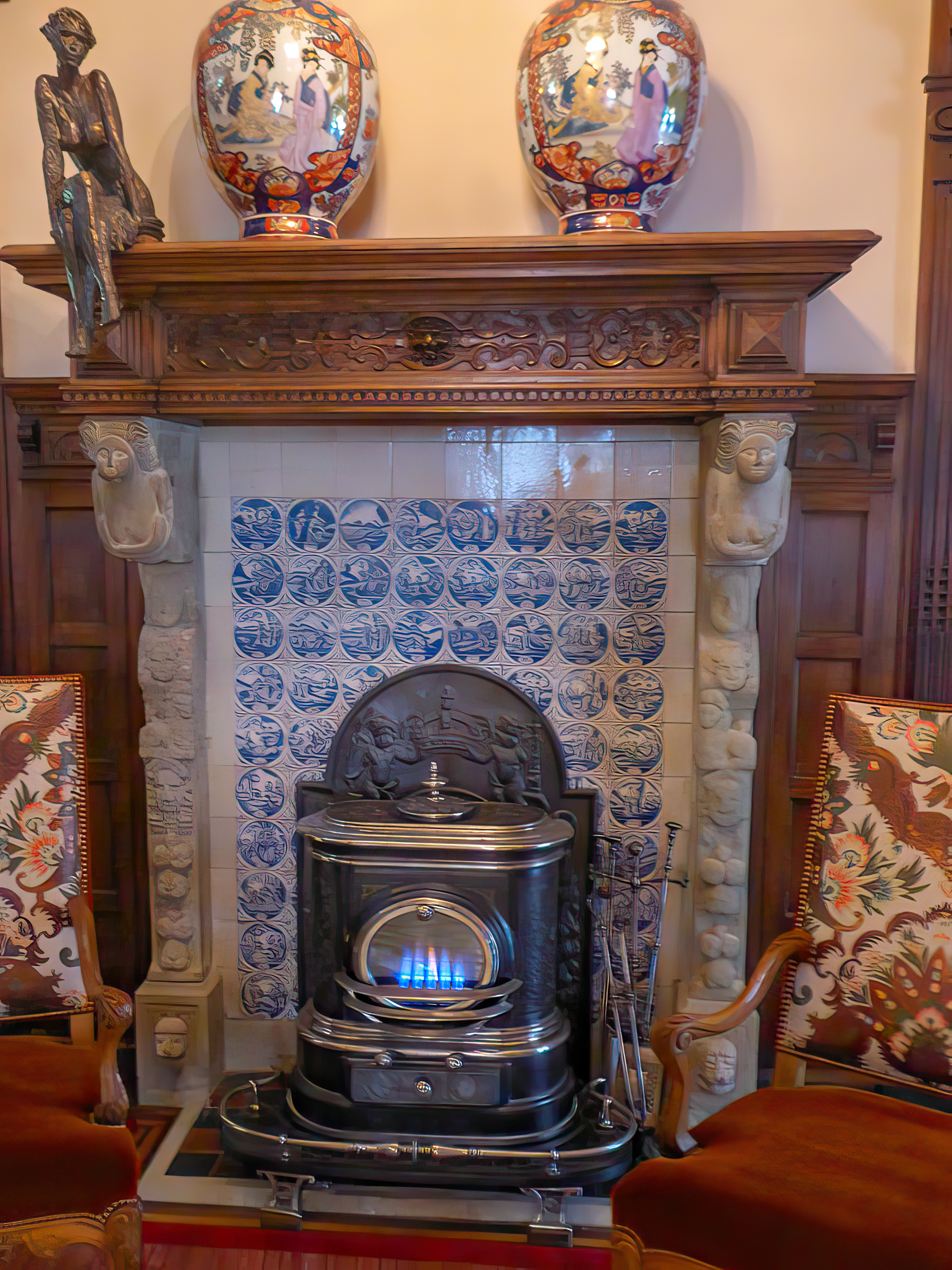 Antique stove with a fireback as heat shield in front of a tile wall