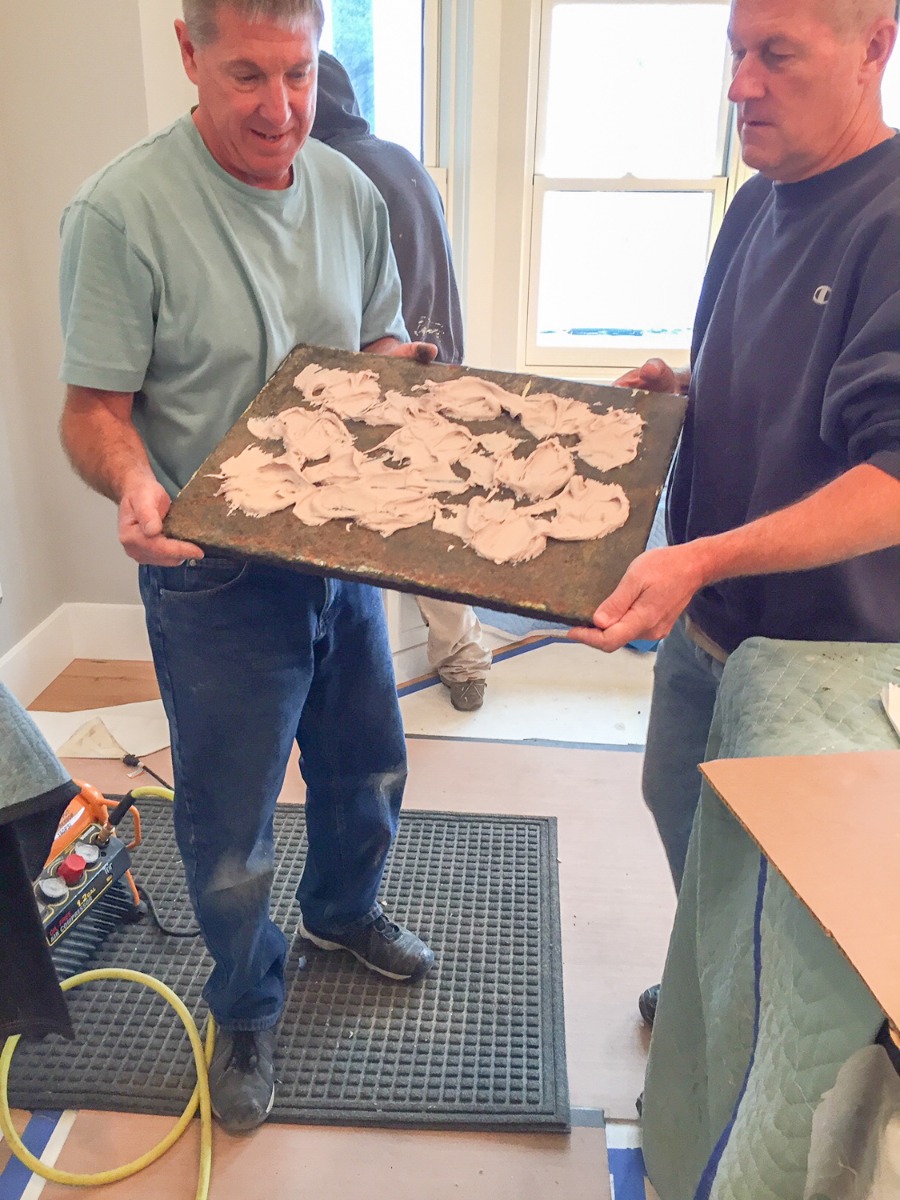 Construction adhesive for wall-mounting a fireback backsplash in a kitchen