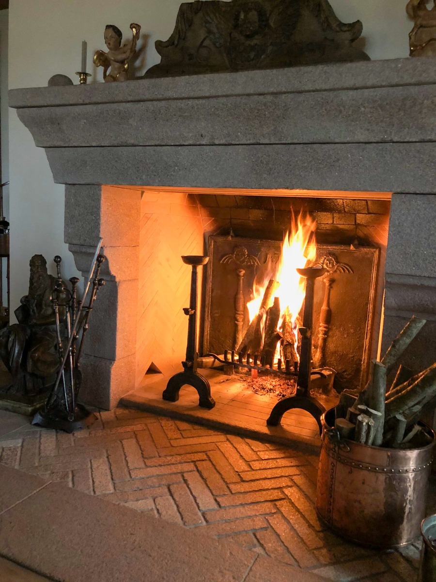 A sturdy Polish fireplace with sturdy, antique French fireback and andirons