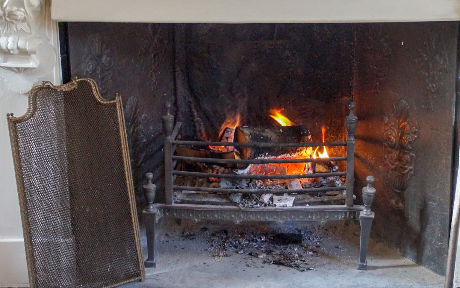 The antique folding fireplace screens are decorative even when folded