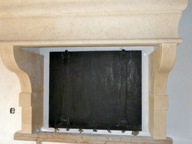 Wall-mounted fireback backsplash with mounting brackets